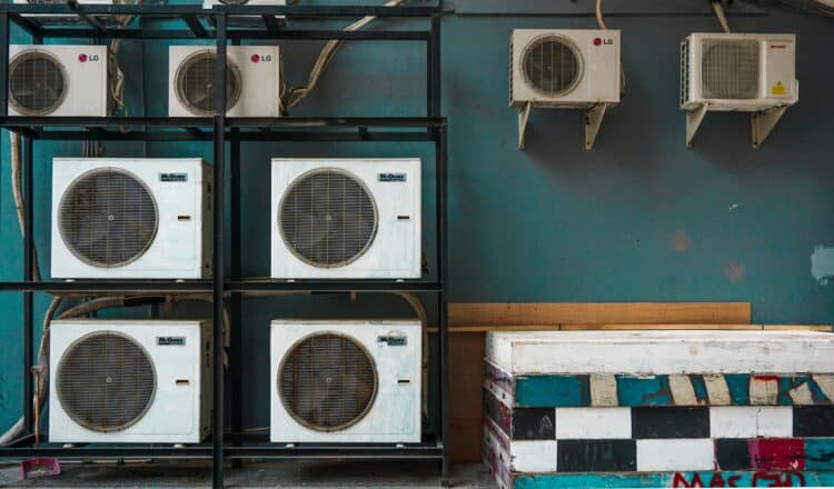 Multiple outdoor air conditioning units mounted on a wall for residential and commercial cooling systems